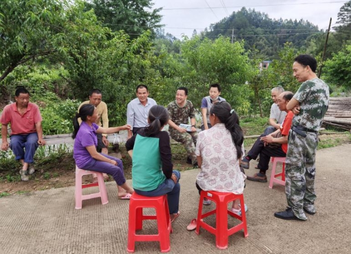 第一書記吳峰（后排左四）與村民討論人居環境美化方案。 （關基景 攝）